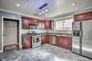 a kitchen with wooden cabinets and a stainless steel refrigerator at NOLA Home with Porch and Grill 4 Mi to French Quarter in New Orleans