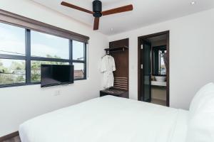 a bedroom with a ceiling fan and a tv at Le Petit Villa Hoi An in Hoi An
