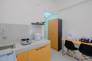 - une cuisine avec un comptoir et 2 chaises dans l'établissement Cozy Studio Bogorienze Resort Apartment By Travelio, à Bogor