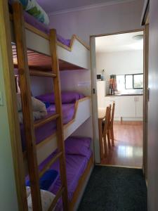 a room with bunk beds and a dining room at Zeehan Bush Camp in Zeehan