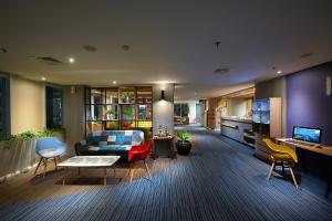 a living room with a couch and some chairs at Deka Hotel Surabaya HR Muhammad in Surabaya
