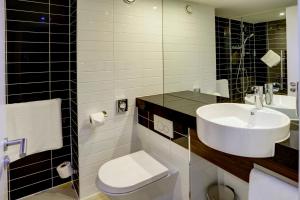 bagno bianco con lavandino e servizi igienici di Holiday Inn Express London - ExCel, an IHG Hotel a Londra