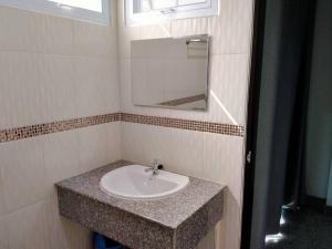 a bathroom with a sink and a mirror at โรงแรมคูณคีม in Nakhon Phanom