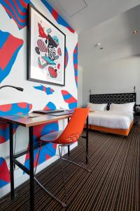 een slaapkamer met een bureau en een bed bij The Constance Fortitude Valley in Brisbane
