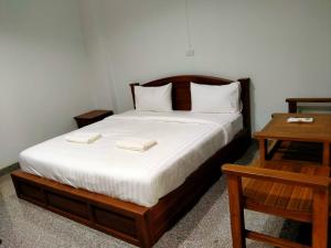 a bedroom with a bed with two towels on it at โรงแรมคูณคีม in Nakhon Phanom +17 photos
