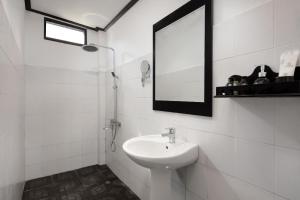 Baño blanco con lavabo y espejo en Sansan Resort, en Vang Vieng