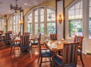 um restaurante com mesas e cadeiras de madeira e janelas em Holiday Inn Hotel French Quarter-Chateau Lemoyne, an IHG Hotel em Nova Orleans
