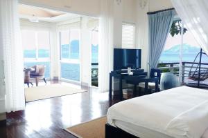 a bedroom with a bed and a desk with a television at Matinloc Resort in El Nido