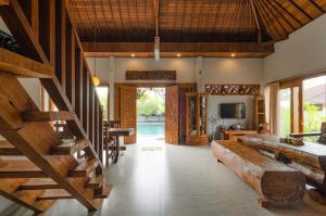 a living room with a couch and a television in a house at Fins Villa Medewi in Airsatang