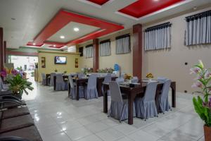 a banquet hall with tables and chairs in a restaurant at RedDoorz Syariah @ Hotel Wisma Indonesia Kendari in Kendari