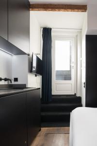 a black and white kitchen with a window at City centre studio canal belt in Amsterdam