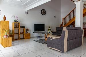 a living room with a couch and a tv at Le Quindio in Bras-Panon
