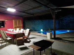 ein Zimmer mit einem Tisch und Stühlen sowie einem Pool in der Unterkunft Le Quindio in Bras-Panon