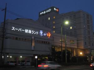 um edifício com escrita ao lado à noite em Route Inn Grantia Fukuyama Spa Resort em Fukuyama