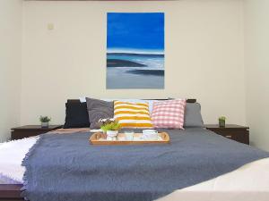 a bed with a tray with two cups on it at Melaka Afamosa Villa with Private Pool for 10 pax in Kampong Alor Gajah