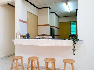 a bar with three wooden stools in a room at Melaka Afamosa Villa with Private Pool for 10 pax in Kampong Alor Gajah