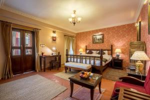 a bedroom with a bed and a living room at Baber Mahal Vilas - The Heritage Hotel in Kathmandu +72 photos