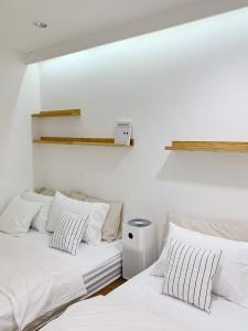 two beds in a room with white walls at Marlowe-Tony's home in Bangkok