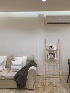 uma sala de estar com um sofá e ar condicionado em Marlowe-Tony's home em Bangkok