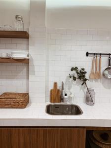 a kitchen counter with a sink with a vase at Marlowe-Tony's home in Bangkok