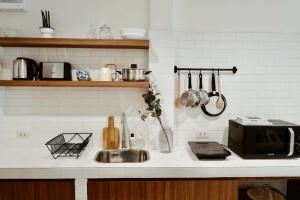 a kitchen counter with a sink and a microwave at Marlowe-Tony's home in Bangkok +50 photos