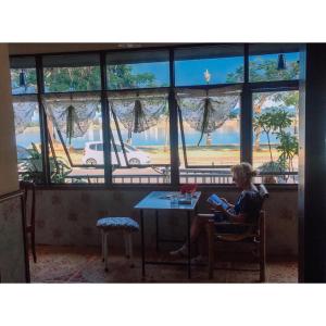 a woman sitting at a table with a book at Take A Rest At Nakhon Phanom in Nakhon Phanom