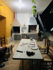 リオパルにあるCasa rural LAS TABLASのピザオーブン付きのキッチン(白いテーブル付)