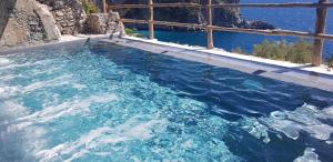 una piscina de agua azul con vistas al océano en Cannaverde - Amalfi Coast Camp, en Maiori