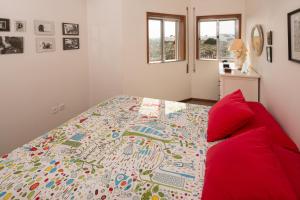 um quarto com uma cama e um sofá vermelho em Barra Beach House - Praia da Barra em Praia da Barra