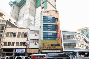 a city street with cars parked in front of a building at OYO 416 Lucky Hotel in Manila