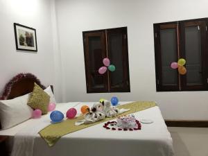 a bed with balloons and a cake on it at Elephant Boutique Hotel in Luang Prabang