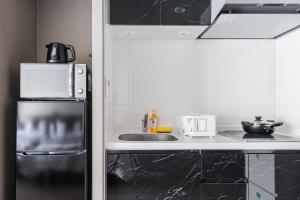 a kitchen with a refrigerator and a sink at BON Condominium Namba Ebisu in Osaka