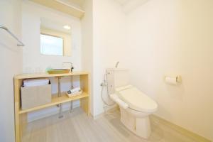 a white bathroom with a toilet and a sink at Apartment HOTEL KIRO Kyoto STATION in Kyoto +43 photos