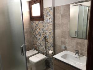 ein Badezimmer mit einem Waschbecken, einem WC und einem Spiegel in der Unterkunft Affittacamere Prestige in Mazara del Vallo