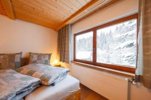 sypialnia z łóżkiem i oknem ze śniegiem w obiekcie Gästehaus Strauss w mieście Seefeld in Tirol