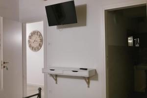 a clock on the wall next to a white wall at LA LOGGETTA affittacamere in Bassano del Grappa