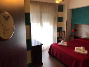 Un dormitorio con una cama roja con toallas. en Affittacamere Prestige en Mazara del Vallo