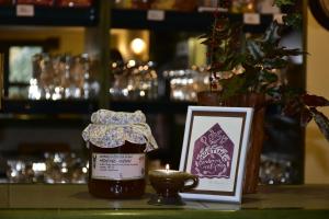a jar of honey next to a candle and a picture at Hostinec U Čertova mlýna in Libavské Údolí
