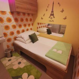 ein Schlafzimmer mit einem Bett mit einem Spiegel und dem Eiffelturm in der Unterkunft Elisabeth Hostel in Wien