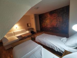 una habitación de hotel con 2 camas y un cuadro en la pared en Hotel Gacka, en Otočac