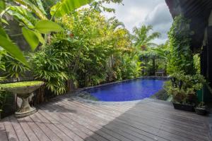 a swimming pool in the middle of a garden at Villa Latebra in Lovina