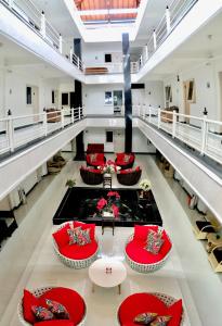 a large lobby with red chairs and a pond in the middle at Gading Guest House in Mataram
