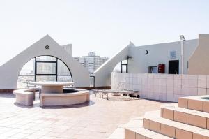 un bâtiment avec une table et des bancs sur un toit dans l'établissement Strand Pavilion, à Strand