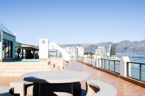 a table on a balcony with a view of the water at Strand Pavilion in Strand