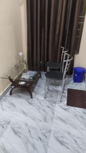 een woonkamer met een tafel en een stoel bij Woodland Lodge and Restaurant in Guwahati