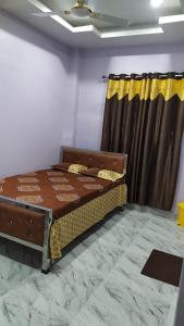 1 dormitorio con cama y cortina en Woodland Lodge and Restaurant en Guwahati