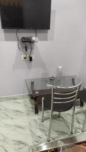 un tavolo in vetro e una sedia in una stanza di Woodland Lodge and Restaurant a Guwahati