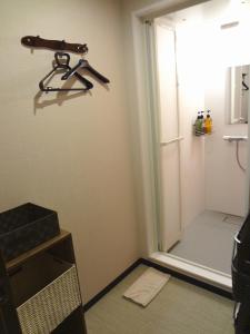 a shower stall with a door and a gun on the wall at Guesthouse kukuru in Wakayama