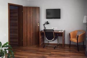 a room with a desk and a chair and a television at Cabrio Apart Hotel in Cluj-Napoca