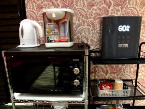 un forno a microonde con una macchinetta del caffè sopra di Guesthouse kukuru a Wakayama